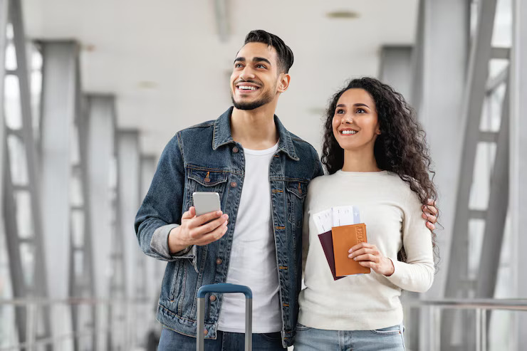 millennial-arab-couple-standing-airport-together-looking-away_116547-25361